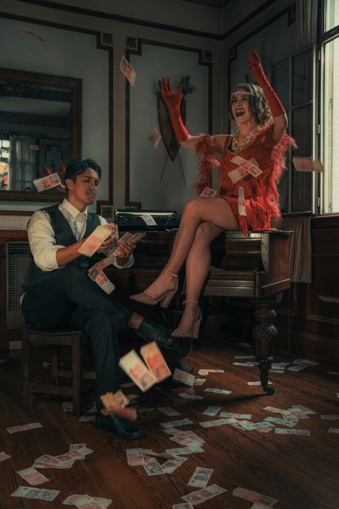 A vintage 1920s themed photo of a couple tossing banknotes with flapper style indoors.